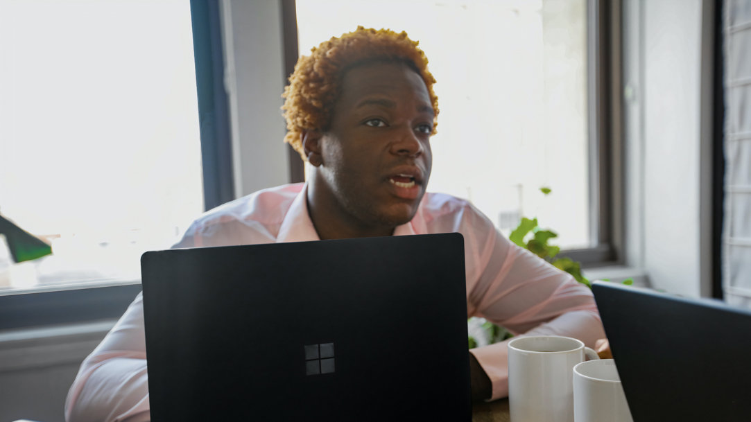 A person using a Microsoft Windows laptop at a table