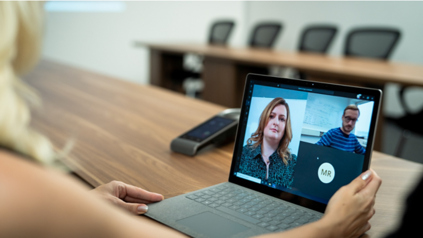 A person using a meeting app on a Surface laptop