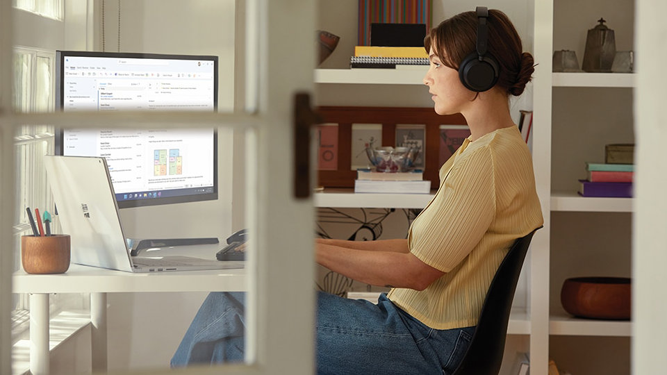 Mattfekete színű Surface Headphones 2 fejhallgatót viselő személy