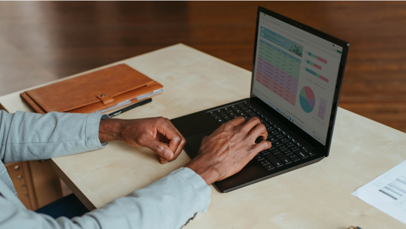 A person with a laptop on a desk uses Microsoft Edge browser to find their IP address