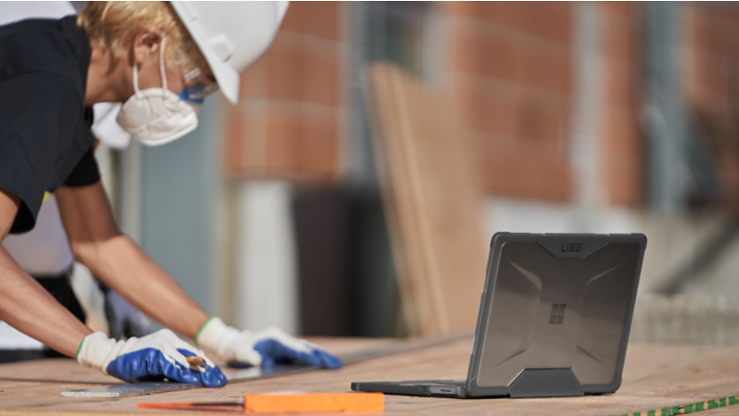 A person working on a Surface laptop at a construction site