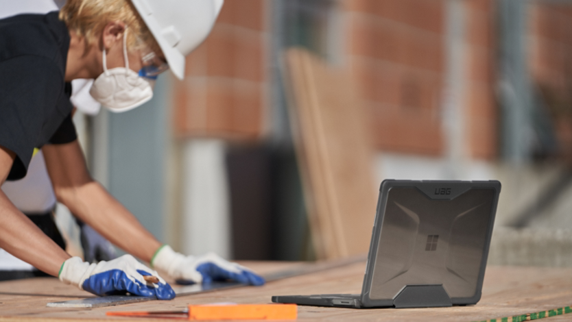 A person working on a Surface laptop at a construction site