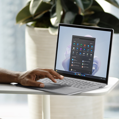 Se observa el dedo de una persona que toca la pantalla de un dispositivo Surface Laptop 5