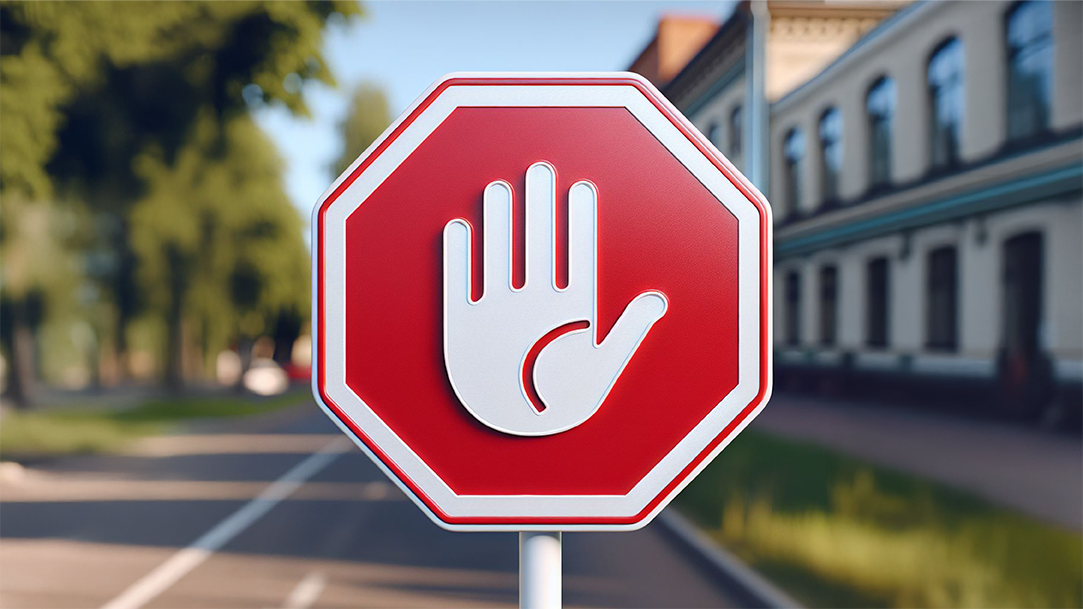 A red stop sign with an image of a palm-open hand in the center