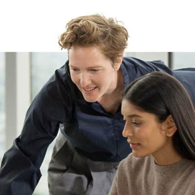 Zwei Personen arbeiten gemeinsam an einem Surface Laptop 5