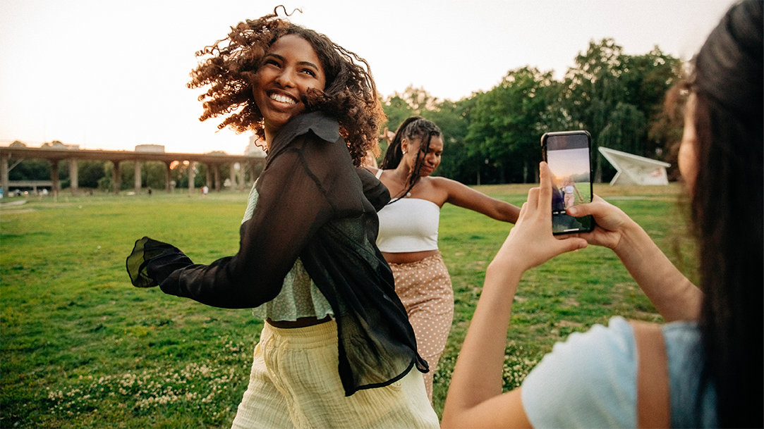 A teenage girl photographs her happy friends
