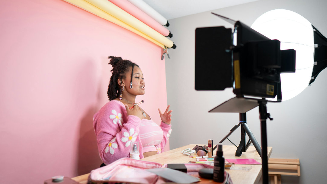 A woman content creator standing at a desk making a video