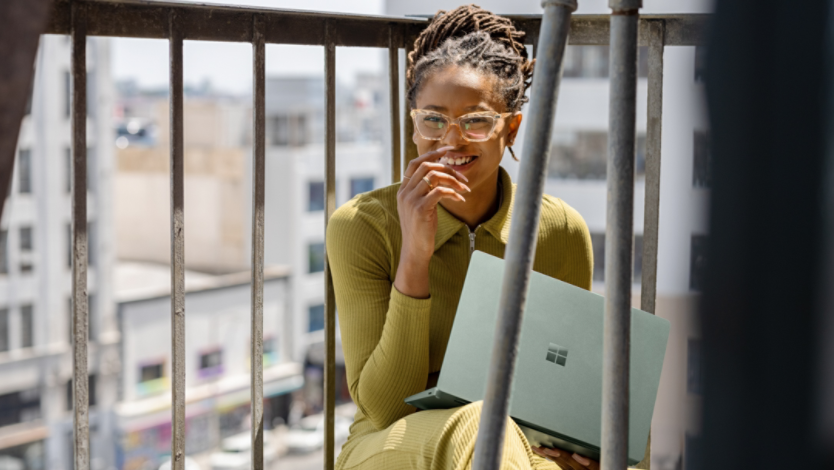 A woman holding a Surface Laptop 5 on her lap