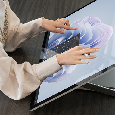 一名女性與 Surface Studio 2+ 的螢幕互動