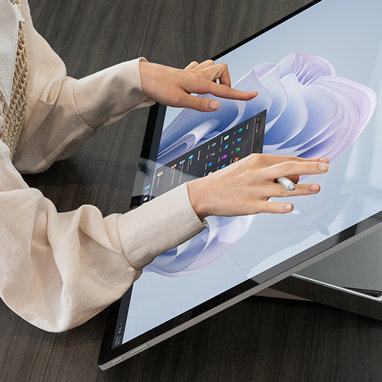 Uma mulher a interagir com o ecrã de um Surface Studio 2+