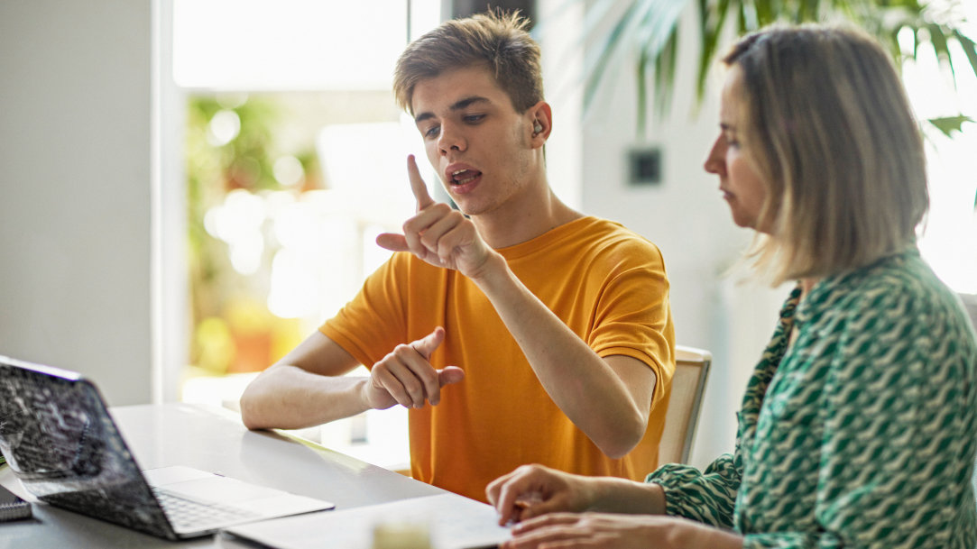 A woman sitting in a wheelchair using a Surface device