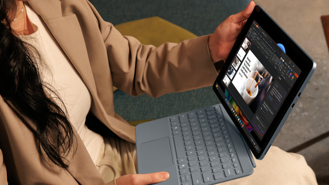 A woman transforms her Surface Pro tablet into a laptop by attaching a Surface Pro keyboard