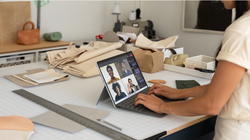 A woman typing a document on a Surface 2-in-1 PC