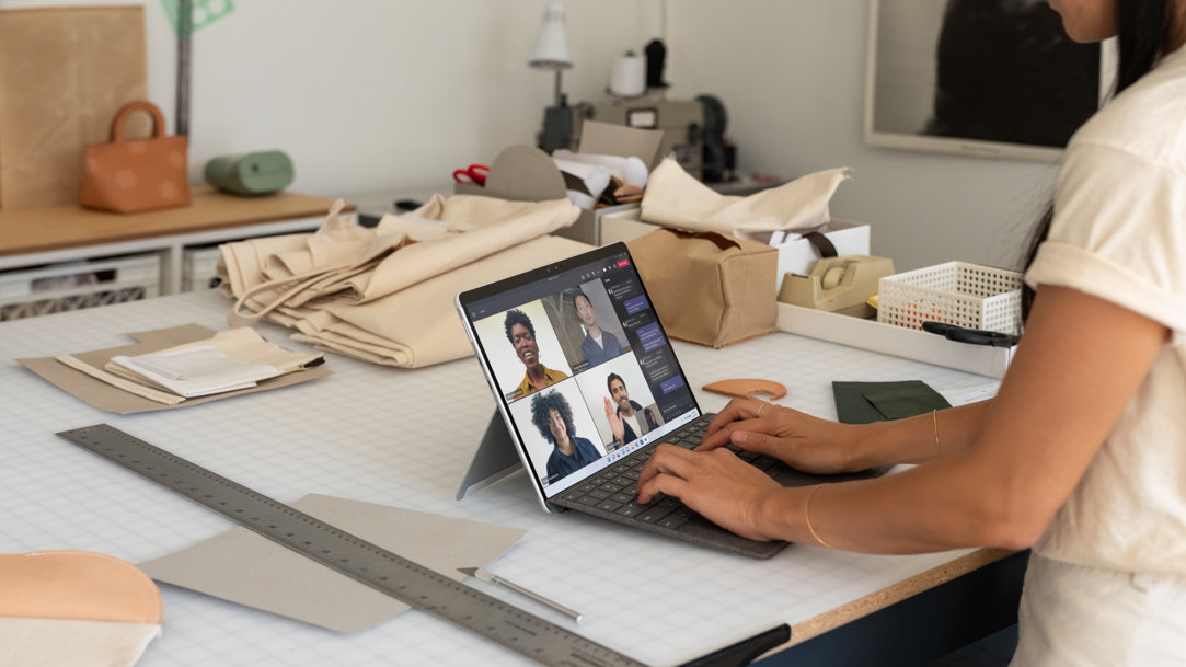 A woman typing a document on a Surface 2-in-1 device