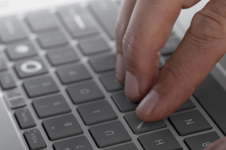 A woman uses the Adaptive Kit attachment to open her laptop lid