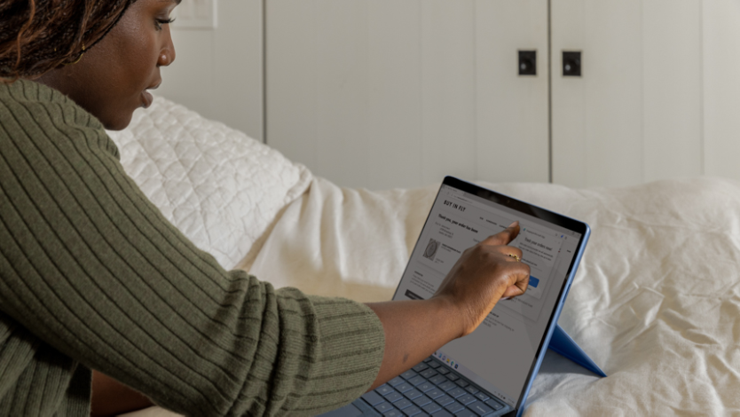 White laptop sitting on a wooden table with Microsoft Edge open