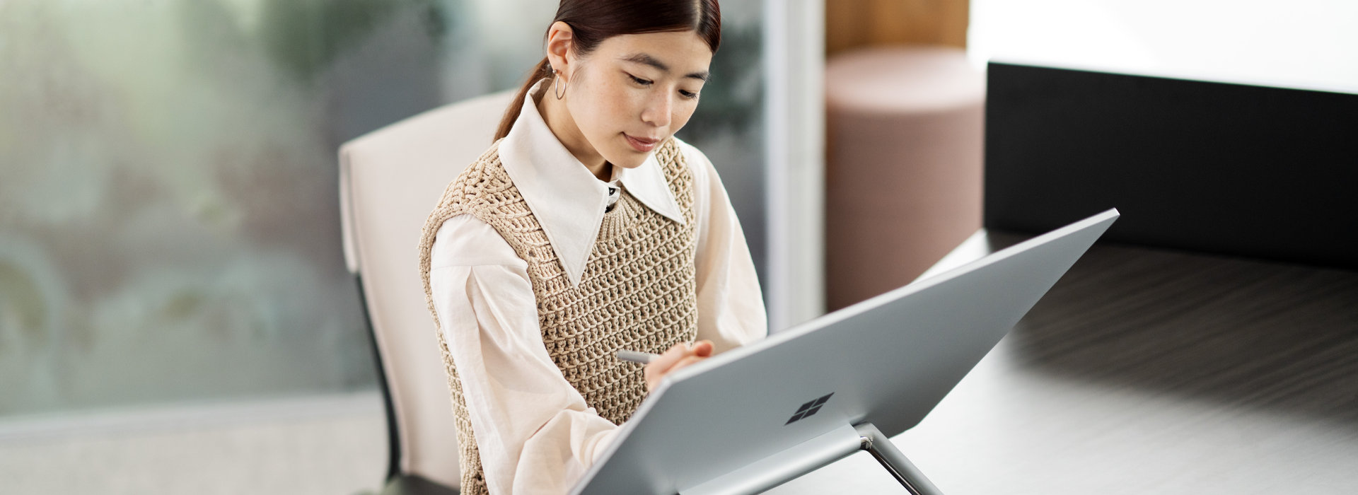 Een vrouw werkt op een Surface Studio 2 Plus op haar thuiswerkplek