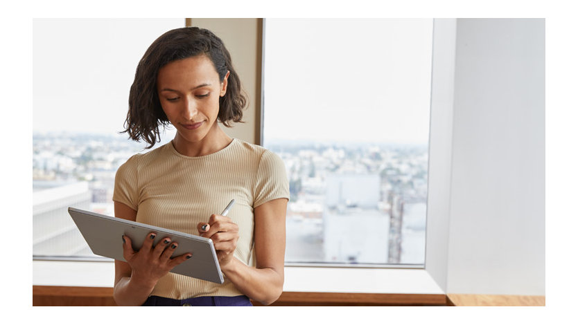 Surface タブレットに Surface ペンで文字を書いている女性