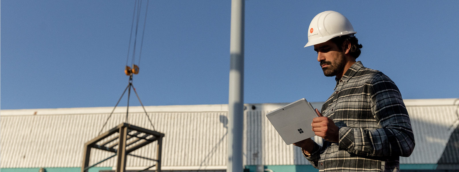 Ein Arbeiter vor Ort hält das Surface Go 2 im Tablet-Modus