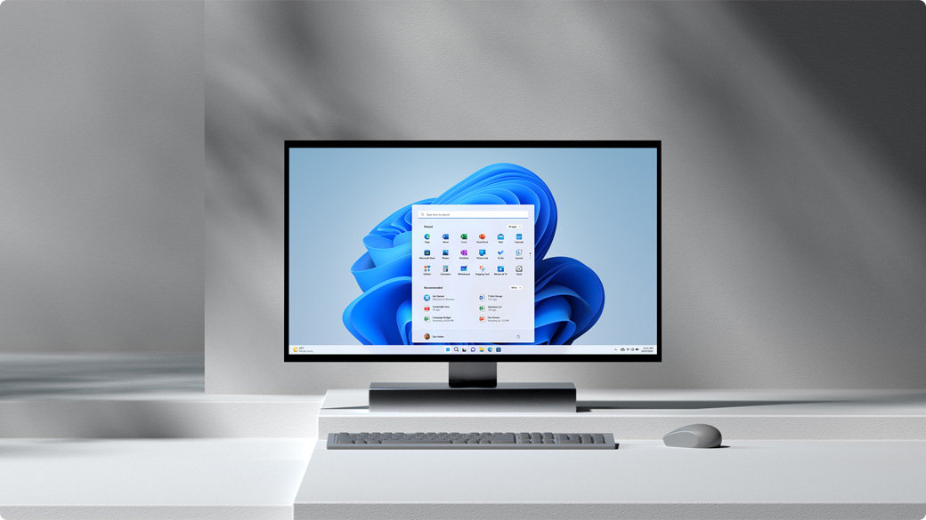 Windows-PC mit Dialogfeld und Blüte im Hintergrund und einer Maus auf einem Tisch