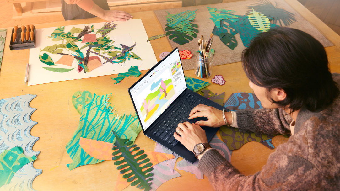 An adult female creating artwork in Paint on her Windows PC laptop