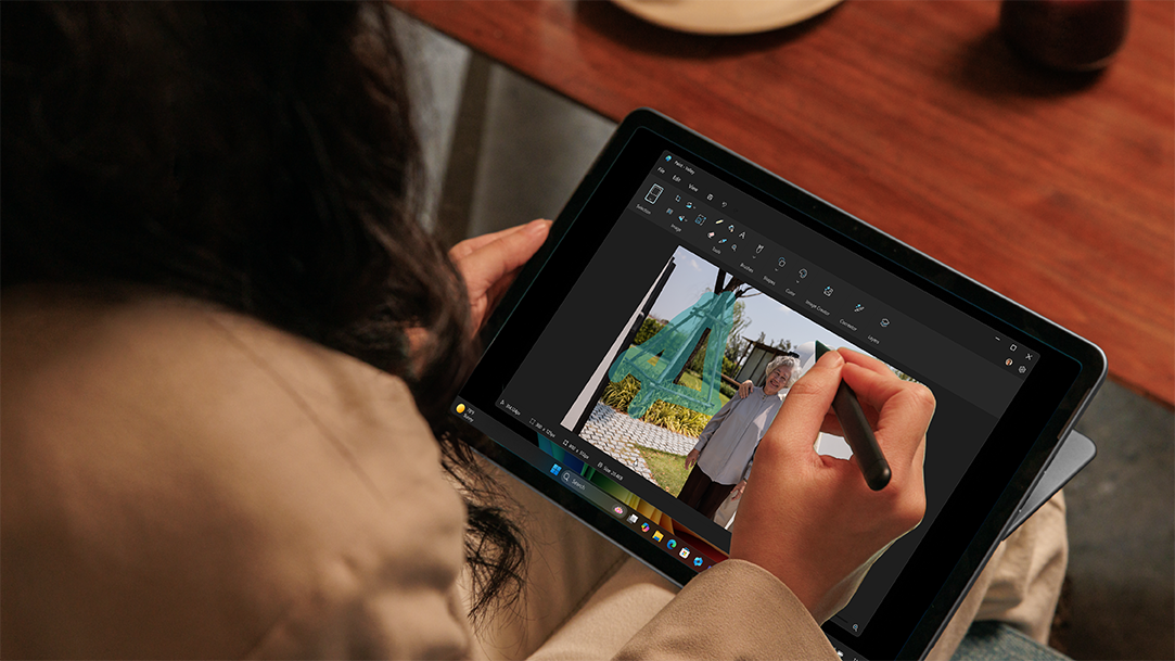 An adult female drawing on a Surface Pro, 12-inch in tablet mode