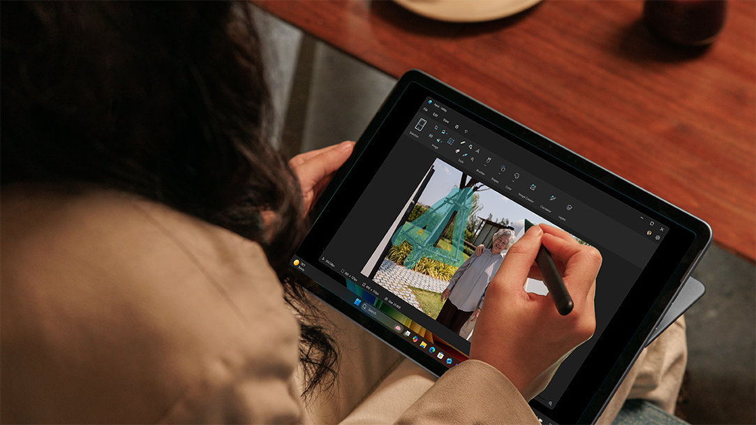An adult female drawing on a Surface Pro, 12-inch in tablet mode