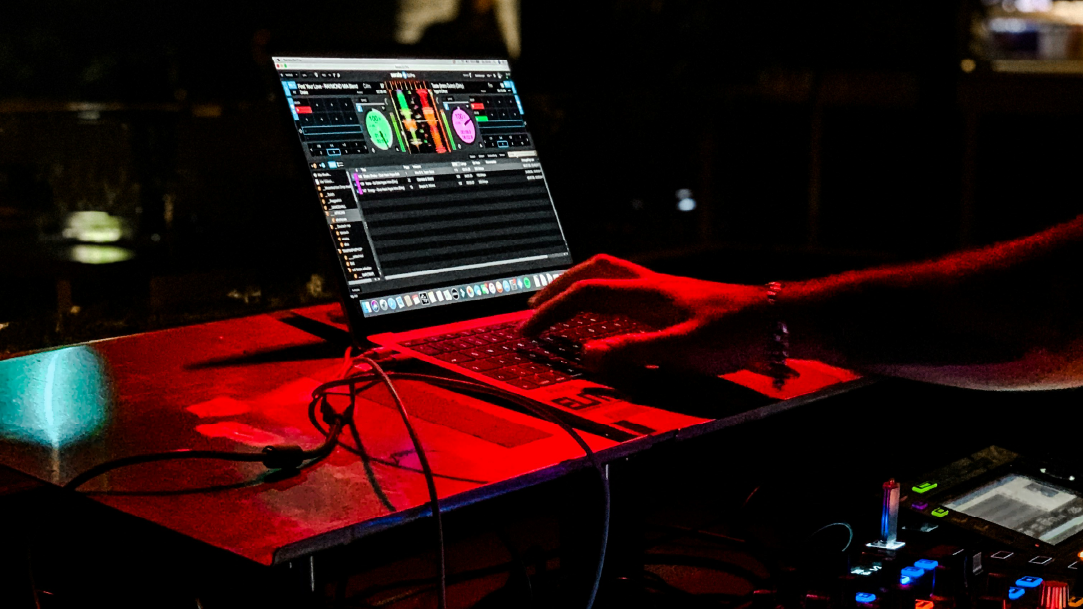 An image of a DJ using a laptop to mix music