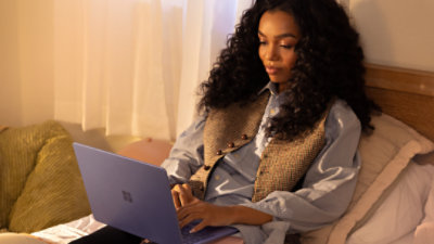 An image of a young adult female using a Surface Laptop 13-inch