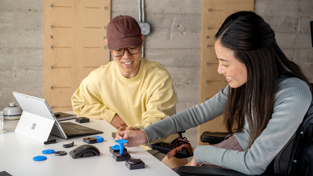An image of a man and woman using a Surface Pro with the Microsoft adaptive accessories