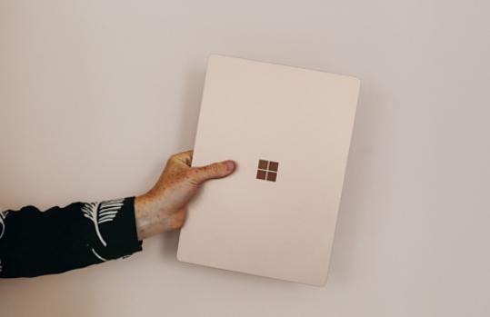 An image of someone holding a Surface laptop in their hand