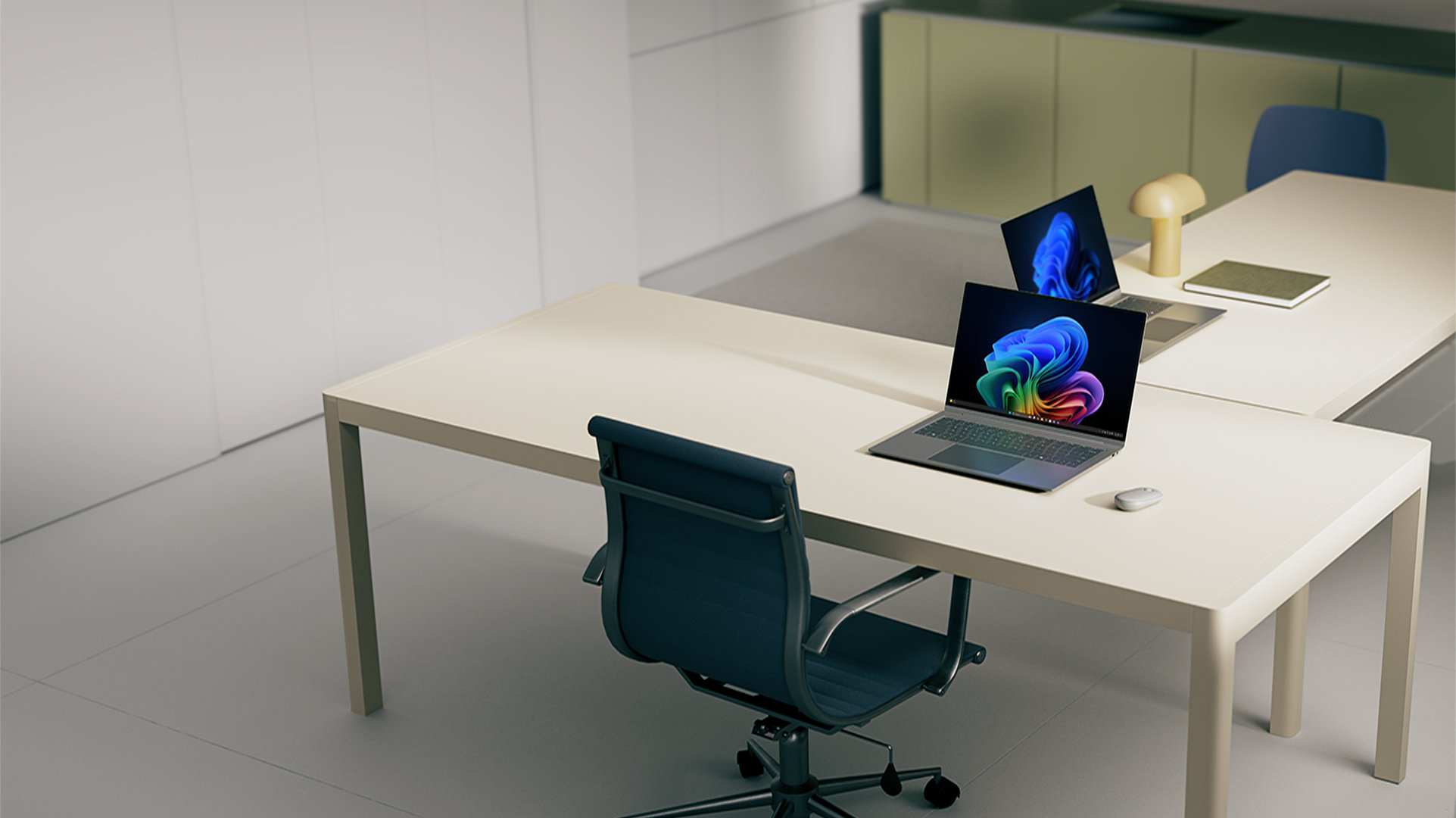 Two office workstations, with desks, both with open Windows 11 Pro PCs displaying bloom images, a mouse, a lamp, and a notebook