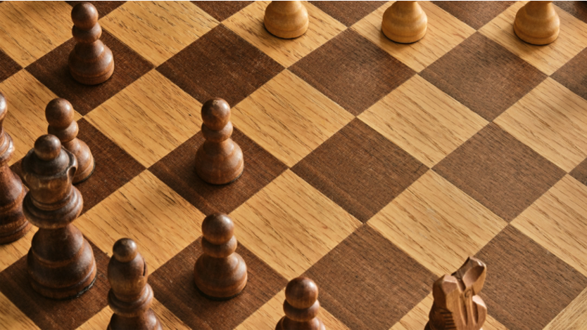 Brown chess pieces on a chessboard
