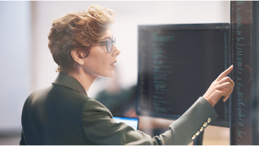 Women in suite pointing to data reading on a computer screen