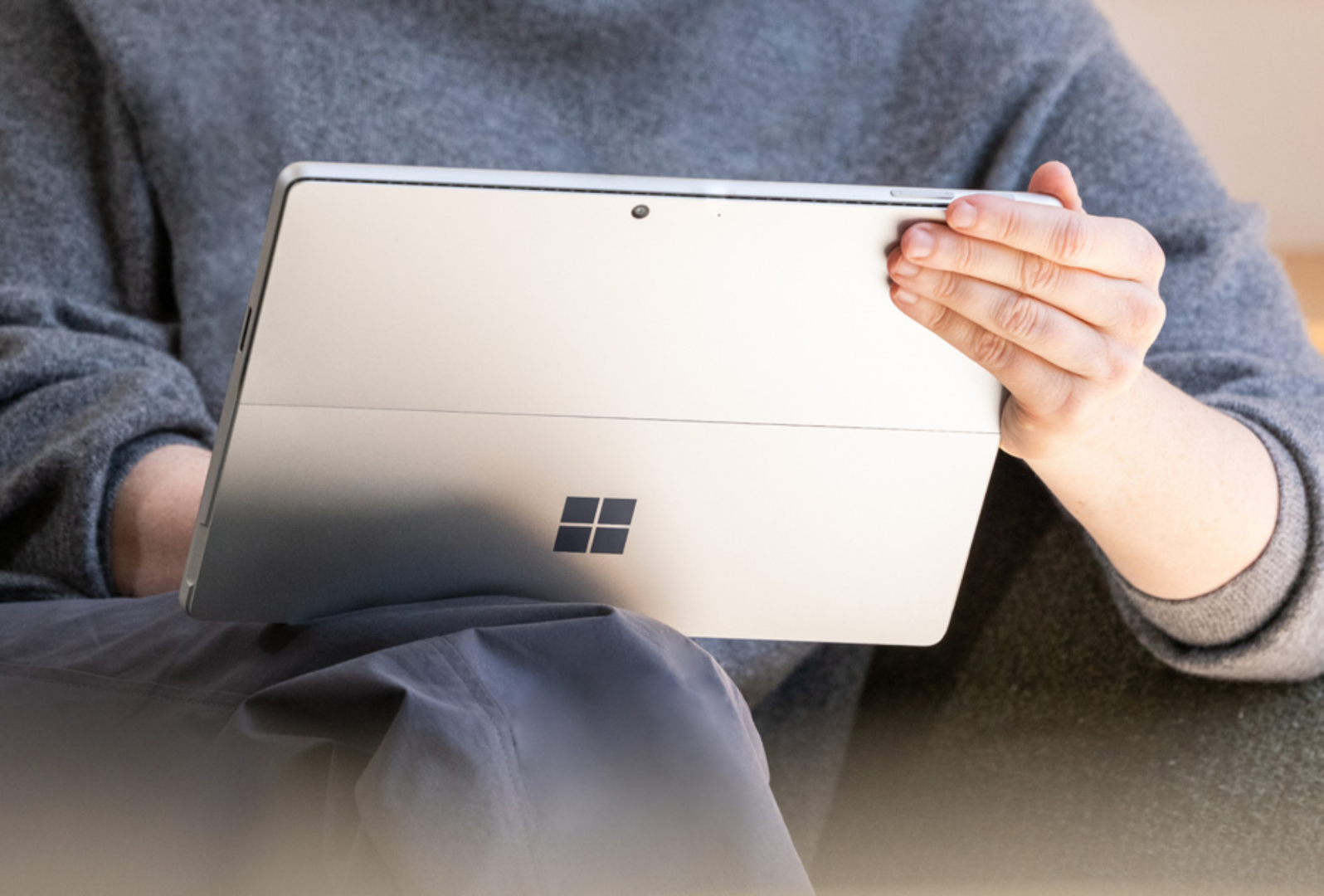 Close up of person holding a Surface device on their lap