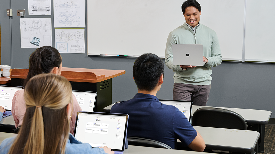 College students and a teacher in a classroom using Surface Pro and Surface Laptop