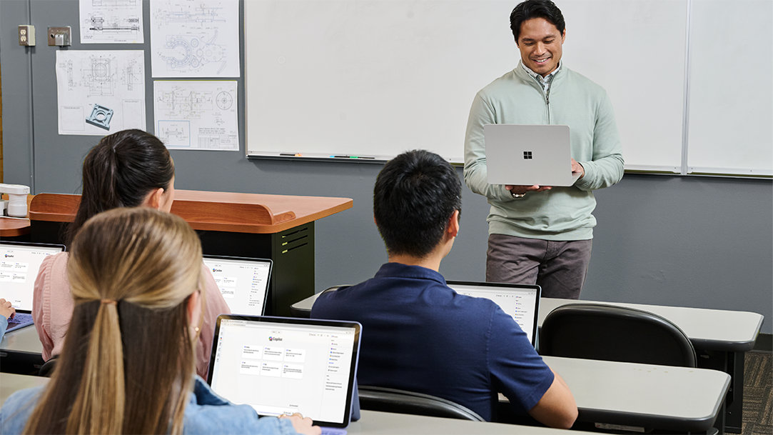 College students and a teacher in a classroom using Surface Pro and Surface Laptop