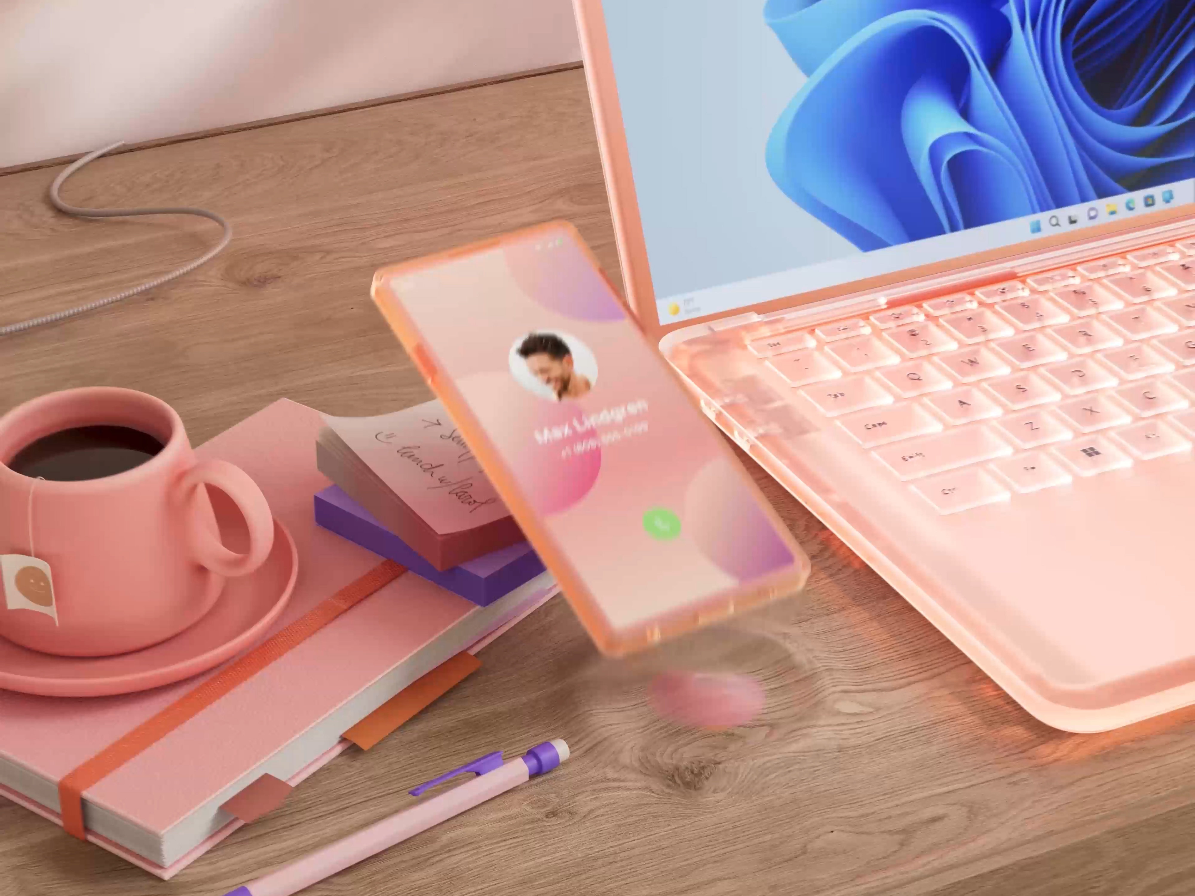 Colourful PC and mobile device sitting on a desk with a cup of coffee and pen