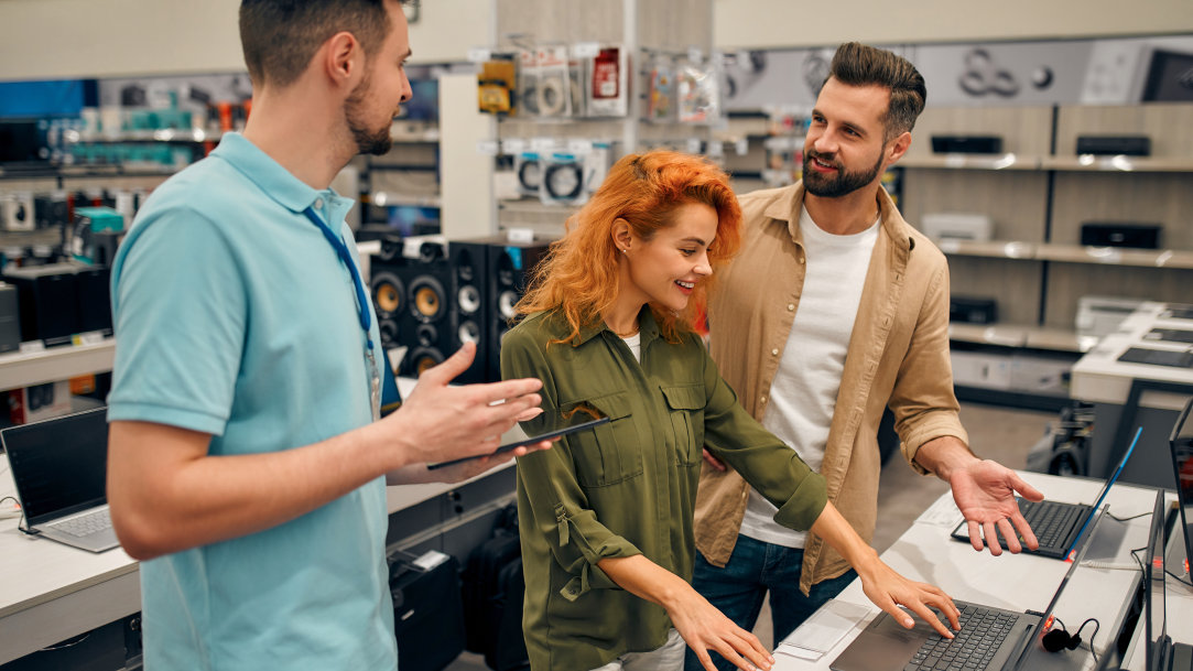 Consumers shopping in a computer store and deciding which laptop to buy