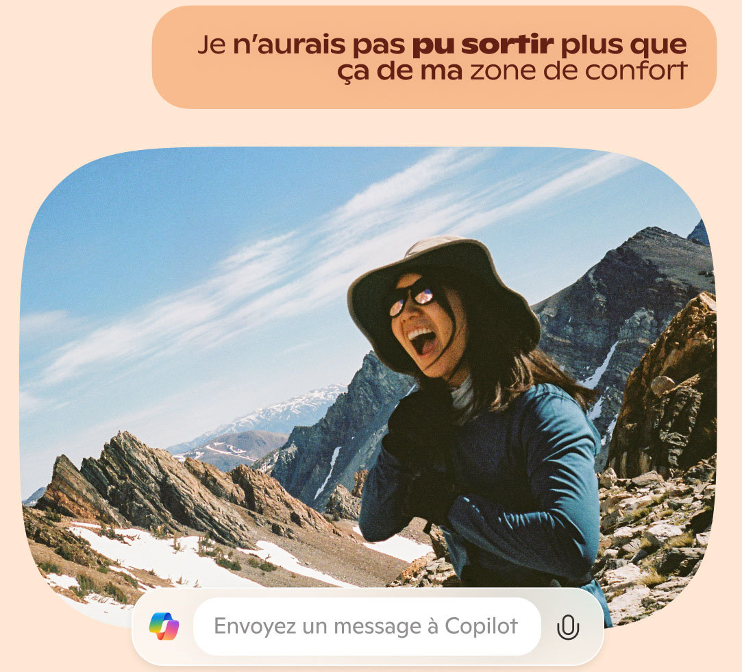 Une jeune femme souriante en tenue de sport qui fait de la randonnée dans des montagnes rocheuses enneigées.