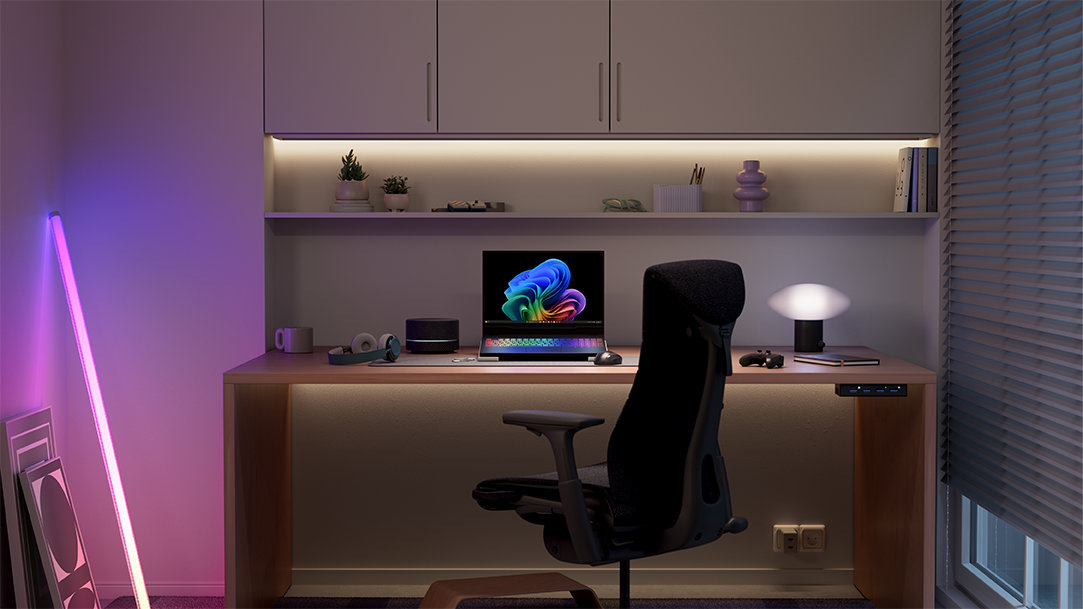 Copilot+ PC on a gaming desk with ergonomic chair, laptop, and lights