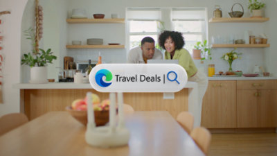 Two people looking at a laptop sitting on the kitchen counter