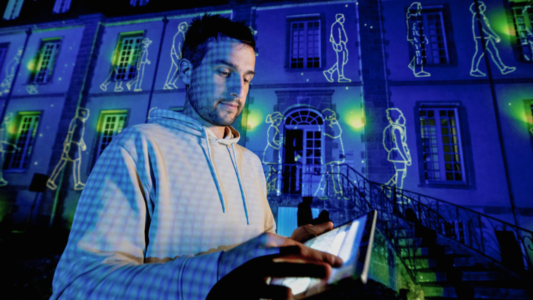 Creative technologist Philippe Dubost works with Surface Pro to prepare a vibrant light projection show in the background