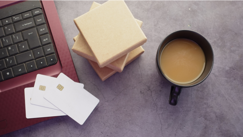 Credit cards and coffee next to a laptop