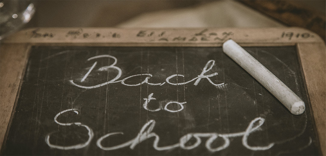 Cursive chalk writing on a blackboard that says “Back to School”