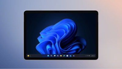 2-in-1 device displaying the Windows 11 operating system with blue bloom. The taskbar shows icons for applications like File Explorer and Microsoft Edge.