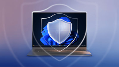 A laptop displaying the Windows 11 operating system with a translucent shield icon overlaid on the screen for security. The background is a gradient of blue and purple. 