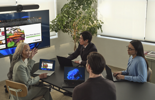 Four People in a meeting going over a slideshow