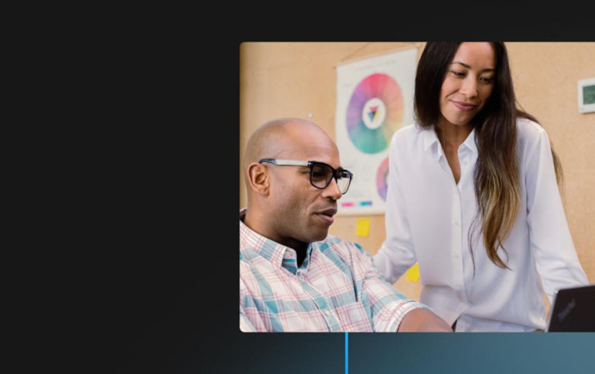 Two co-workers look at the screen of a Windows device