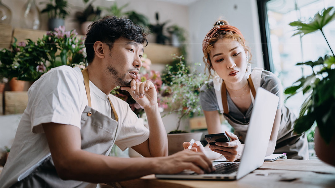 Flower shop owners look up how to sync their phone with their computer for productivity
